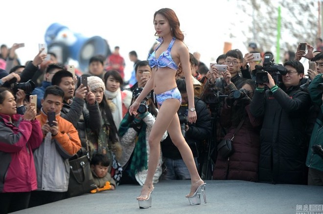 Khán giả mặc áo bông, đội mũ len đứng xem chân dài diễn bikini giữa thời tiết đóng băng - Ảnh 1.