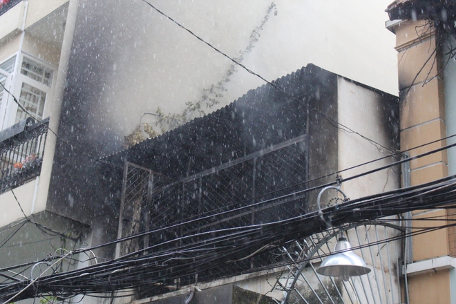 TP HCM: Cảnh sát “đội mưa” chữa cháy căn nhà nằm sâu trong hẻm - Ảnh 1.