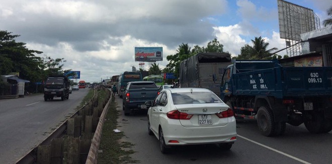 Xe tải rụng bánh lật chắn ngang cầu Mỹ Thuận, tắc đường 10km - Ảnh 2.