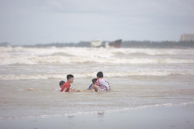 Bất chấp sóng to, gió lớn, nhiều người vẫn ra tắm ở biển Cửa Lò - Ảnh 2.