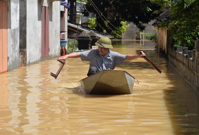 Chùm ảnh: Nhà ngập sâu đến ngang cửa, người dân Ninh Bình dùng chậu nhôm, ghế gỗ chèo thuyền đi lại trong ngõ - Ảnh 2.