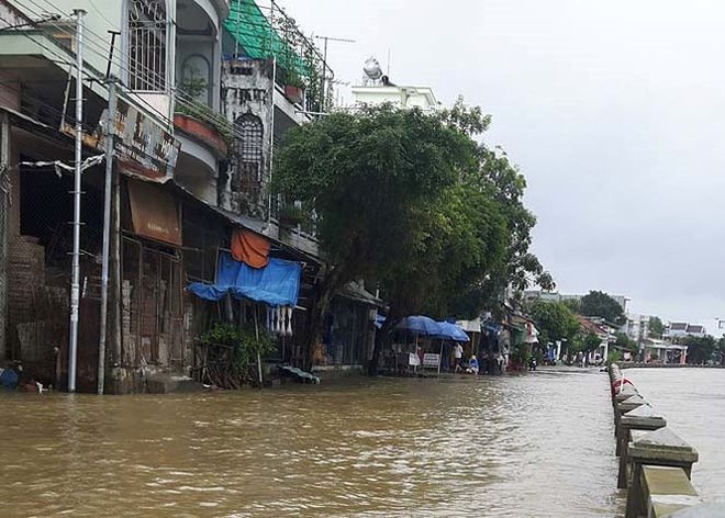 Đường phố Bình Định chìm trong biển nước, người dân dùng máy cày vượt lũ - Ảnh 2.