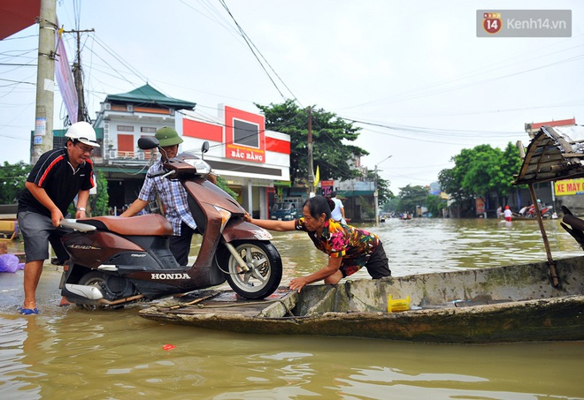 Chùm ảnh: Kiếm bộn tiền từ việc chèo đò qua điểm ngập nặng trong đợt lụt lịch sử tại Ninh Bình - Ảnh 11.