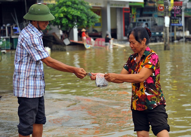 Chùm ảnh: Kiếm bộn tiền từ việc chèo đò qua điểm ngập nặng trong đợt lụt lịch sử tại Ninh Bình - Ảnh 12.