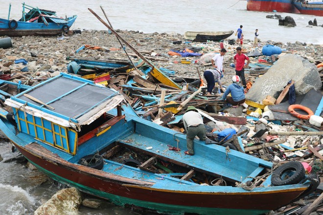 Dân Quảng Bình trục vớt từng mảnh tàu cá vỡ vụn sau bão - Ảnh 3.