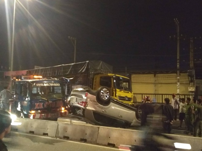 Xe tải ủi ô tô lật ngửa trên đường, 4 người trong xe la hét cầu cứu ở Sài Gòn - Ảnh 1.