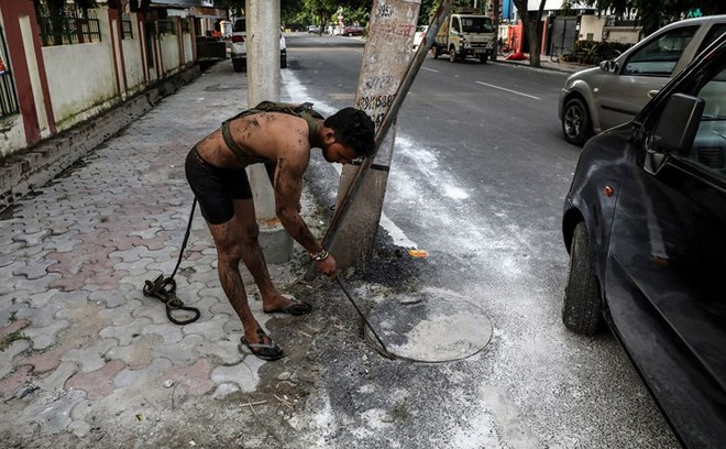 Cận cảnh công việc của các công nhân ngụp lặn trong ống thải ở Ấn Độ - Ảnh 11.