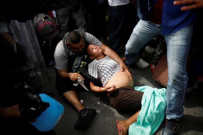 24h qua ảnh: Người di cư mang thai ngất xỉu trên đường tới biên giới Mỹ - Ảnh 3.