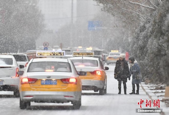 Trung Quốc lạnh âm độ trong trận Đại Tuyết, người dân quấn áo choàng dày như chăn ra đường - Ảnh 7.