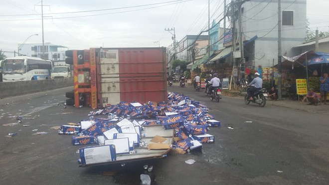 Hàng trăm thùng bia tràn ra đường, nhiều người nhặt mang đi mặc cho tài xế can ngăn   - Ảnh 1.