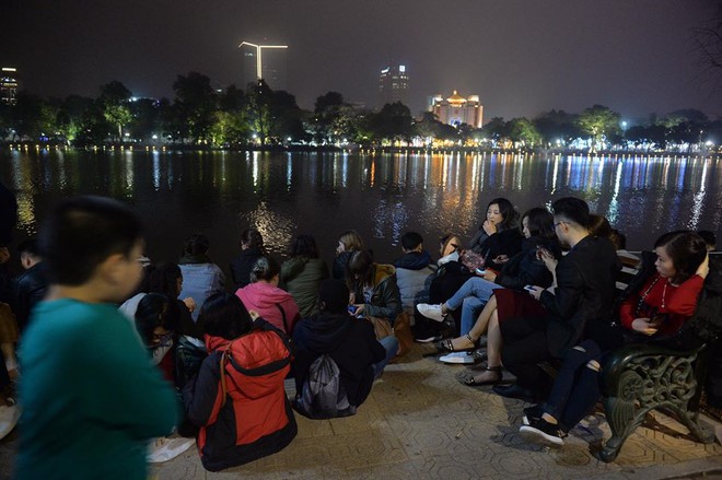 Hàng nghìn người lớn, trẻ em ngồi la liệt ven sông Sài Gòn và Hồ Gươm chờ màn bắn pháo hoa - Ảnh 7.