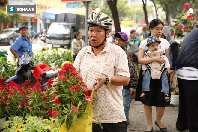 Không bán hết hàng trưa 30 Tết, tiểu thương dùng gậy đập nát chậu hoa, vứt vào thùng rác - Ảnh 1.