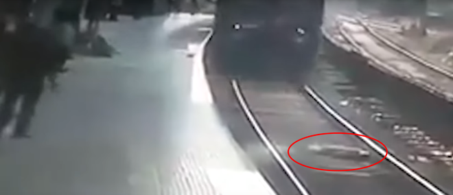 Clip: Người đàn ông lao xuống nằm giữa đường ray khi tàu hỏa đang lao nhanh tới khiến hành khách kinh hãi - Ảnh 2.