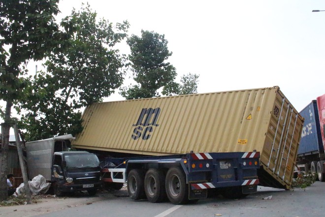Xe container lao như tên qua dải phân cách, húc văng ô tô tải lên vỉa hè - Ảnh 1.