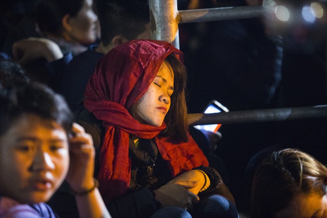 Người phụ nữ mặc áo mưa, ngủ qua đêm trên ghế đá chờ xin ấn đền Trần - Ảnh 13.