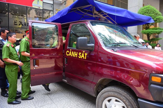 Bộ Công an khám xét chi nhánh Eximbank ở Sài Gòn, đưa 2 người lên xe chuyên dụng - Ảnh 7.