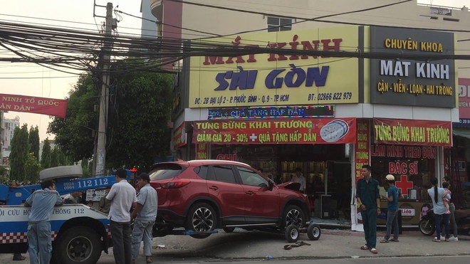 Xế hộp lao vào tiệm mắt kính mới khai trương ở Sài Gòn, 2 cha con chủ tiệm thoát chết - Ảnh 1.