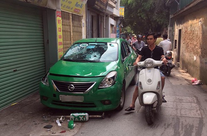 Taxi bị đập vỡ kính, bẻ gương chiếu hậu khi dừng đỗ trên đường phố Hà Nội - Ảnh 1.