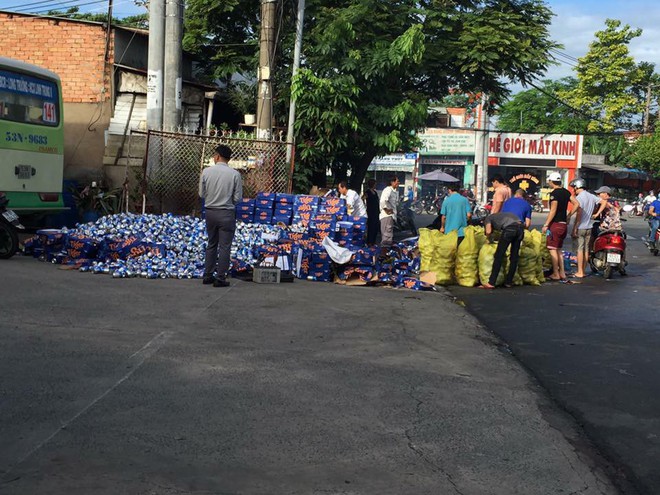 Người dân Bình Dương giúp tài xế gom hàng trăm thùng bia rơi xuống đường  - Ảnh 2.