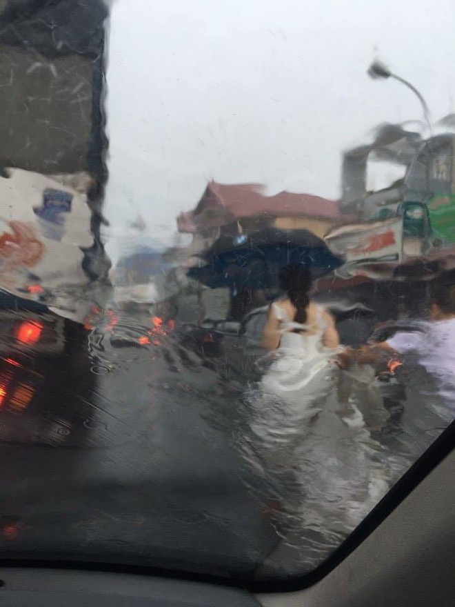 Hình ảnh gây chú ý: Tài xế xe tải che ô, đỡ váy, đưa cô dâu vượt mưa lụt về nhà chồng - Ảnh 2.