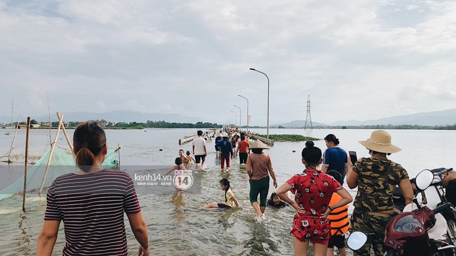 Nước vừa rút lại lên, người già trẻ nhỏ tiếp tục ùa ra đường tỉnh lộ vô tư bơi lội khi phương tiện bị cấm lưu thông - Ảnh 8.