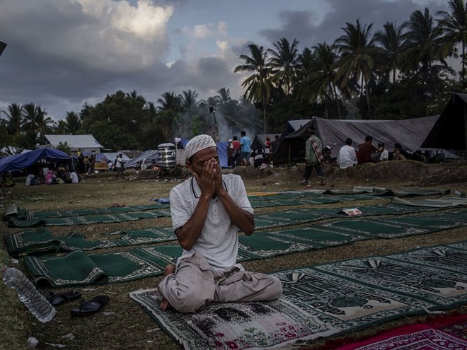 Ảnh: Người dân Indonesia thẫn thờ dọn dẹp đống đổ nát sau động đất - Ảnh 10.