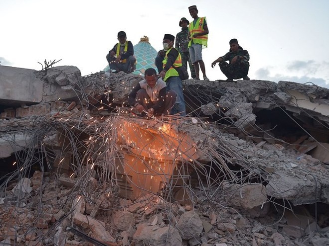 Ảnh: Người dân Indonesia thẫn thờ dọn dẹp đống đổ nát sau động đất - Ảnh 13.