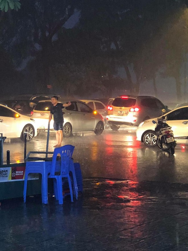 Giữa lúc mưa to, người đàn ông bỏ lại xe chạy ra giữa đường khiến nhiều người khó hiểu - Ảnh 2.