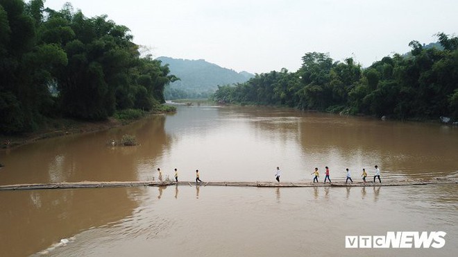 Ảnh: Dân Lạng Sơn diễn xiếc trên cầu tre dài 100m bắc qua sông - Ảnh 1.