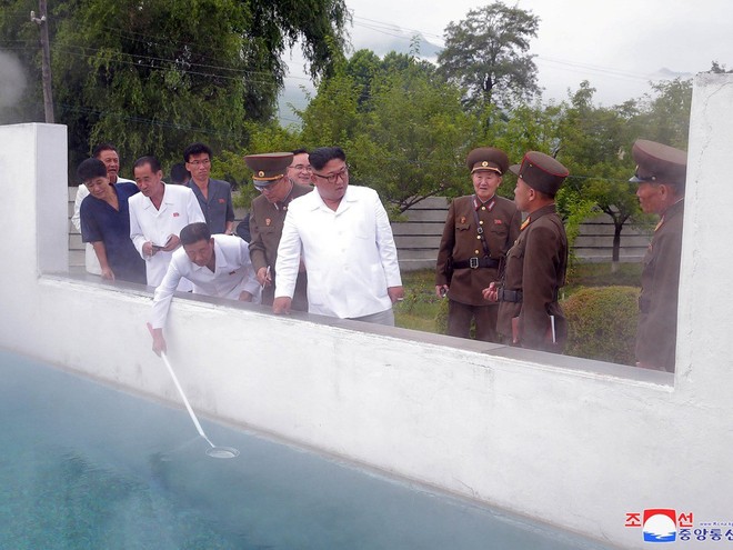 Triều Tiên lần đầu công bố hình ảnh gây sốt: Nhà lãnh đạo Kim Jong-un dầm mưa đi thị sát - Ảnh 6.