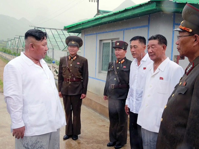 Triều Tiên lần đầu công bố hình ảnh gây sốt: Nhà lãnh đạo Kim Jong-un dầm mưa đi thị sát - Ảnh 10.