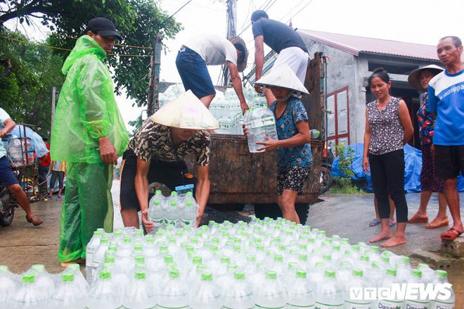 Dân vùng rốn lũ Hà Nội tấp nập chèo thuyền đi lấy nước miễn phí - Ảnh 4.