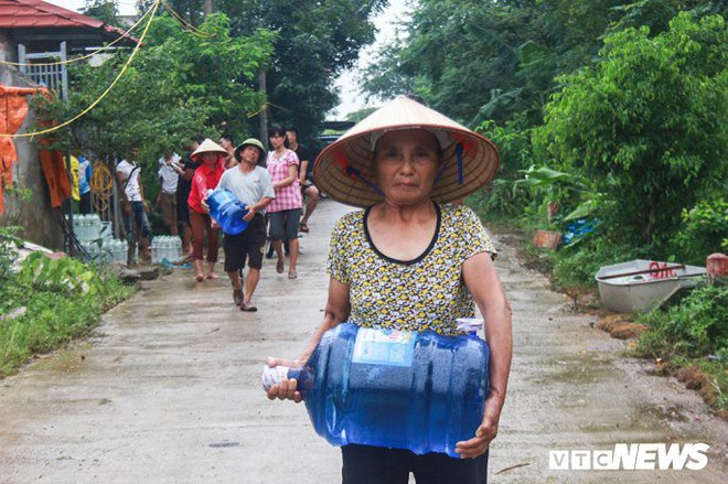 Dân vùng rốn lũ Hà Nội tấp nập chèo thuyền đi lấy nước miễn phí - Ảnh 5.