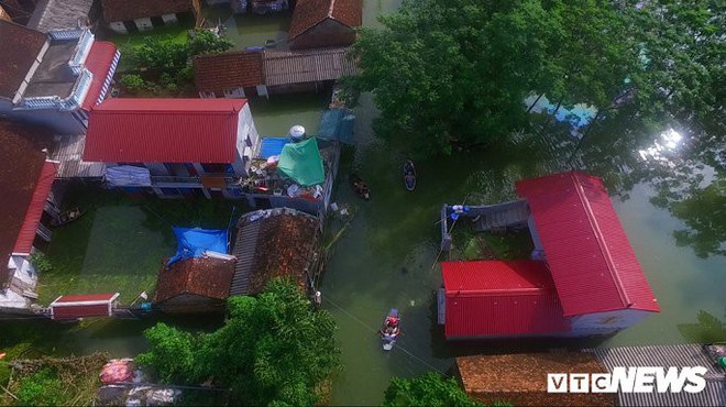 Video Flycam: Nước ngập đầu người, dân Thủ đô đi lại trên mái nhà lấy đồ cứu trợ - Ảnh 7.