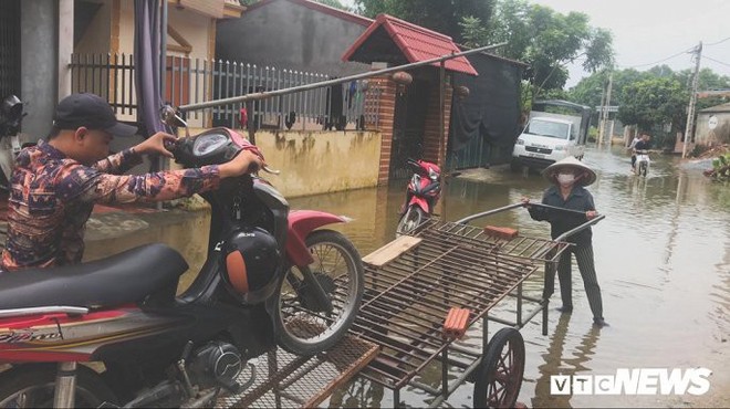 Video Flycam: Nước ngập đầu người, dân Thủ đô đi lại trên mái nhà lấy đồ cứu trợ - Ảnh 9.