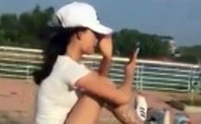 Nữ sinh xăm trổ tay cầm điện thoại, chân điều khiển xe máy phóng vun vút trên đường