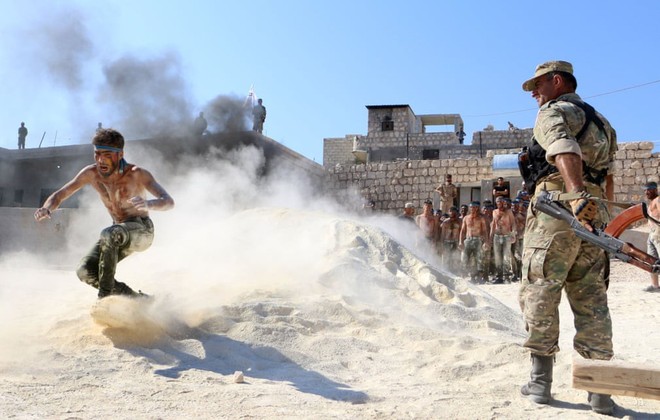 24h qua ảnh: Chiến binh quân nổi dậy Syria cởi trần luyện tập trên cát - Ảnh 3.