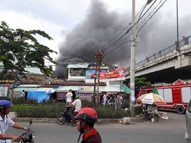 Cháy lớn nhiều nhà dân ở gần cầu Bình Lợi, khói đen bốc cao nghi ngút - Ảnh 1.