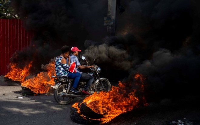 24h qua ảnh: Người biểu tình lái môtô xuyên qua rào chắn lửa từ lốp xe - Ảnh 4.