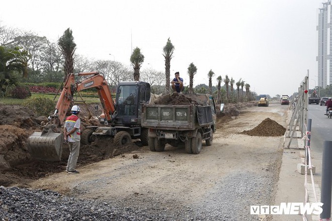 Ảnh: Công nhân xén dải phân cách, mở rộng đường gom Đại lộ Thăng Long - Ảnh 2.