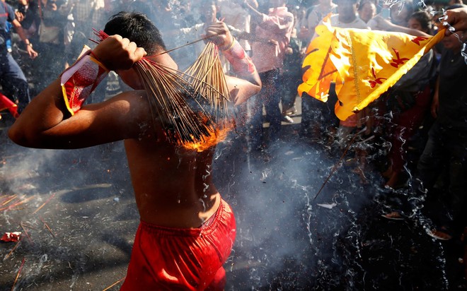 24h qua ảnh: Người Campuchia đốt hương trên lưng trần mừng năm mới - Ảnh 3.
