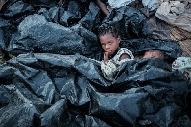 24h qua ảnh: Trẻ em dùng nylon làm chăn ở khu sơ tán Mozambique sau siêu bão - Ảnh 3.