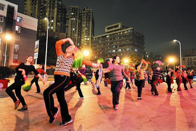 Các bà dì Trung Quốc đeo tai nghe nhảy aerobic ở quảng trường vì sợ làm phiền đến người khác - Ảnh 1.