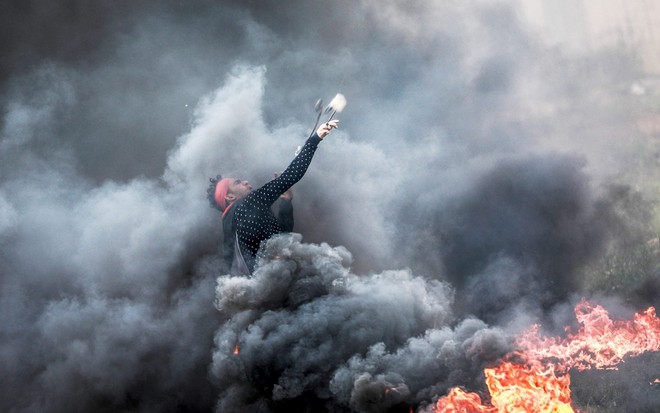 24h qua ảnh: Người biểu tình Palestine bắn đá xuyên khói đen vào lính Israel - Ảnh 4.