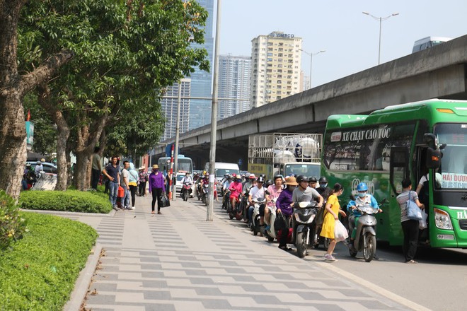 Ôm hoa, vác trẻ, đội nắng đứng ven đường bắt xe về quê nghỉ lễ - Ảnh 4.