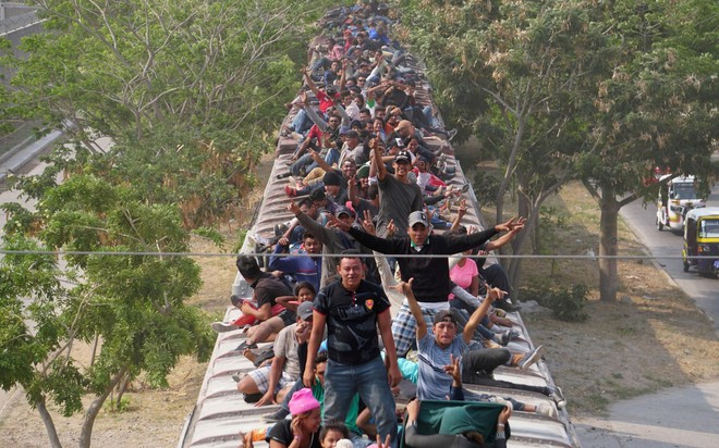 24h qua ảnh: Người di cư trèo lên nóc tàu để tới biên giới Mỹ - Ảnh 4.