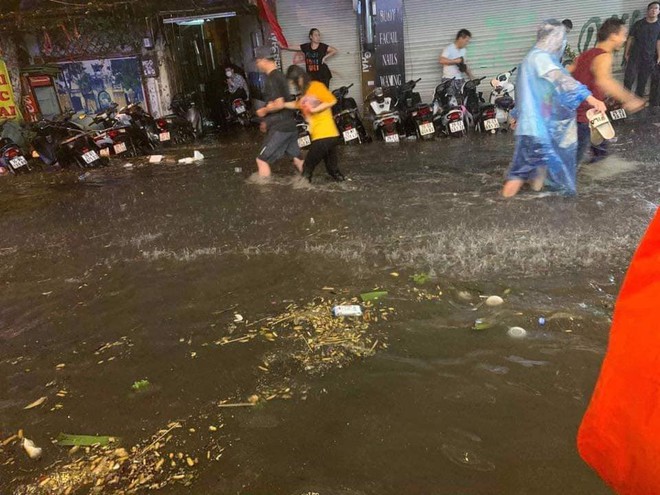 Hà Nội mưa lớn trong đêm khiến nhiều tuyến phố biến thành sông, khách Tây lội bì bõm - Ảnh 2.