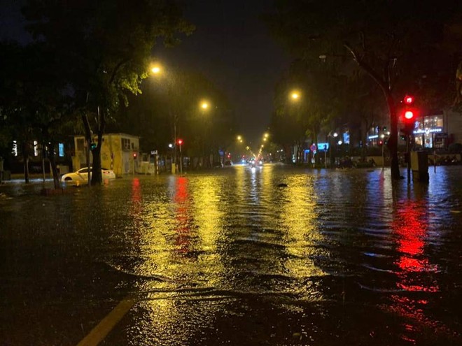 Hà Nội mưa lớn trong đêm khiến nhiều tuyến phố biến thành sông, khách Tây lội bì bõm - Ảnh 1.
