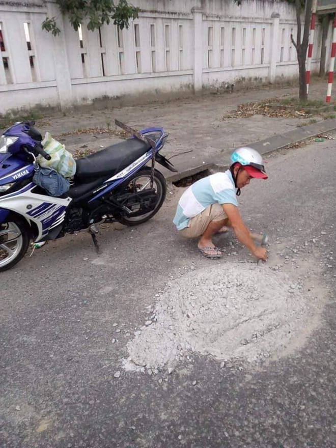 Hì hục đục mảng bê tông bám trên đường vì sợ người khác bị tai nạn, người đàn ông ở Đà Nẵng gây sốt MXH - Ảnh 1.