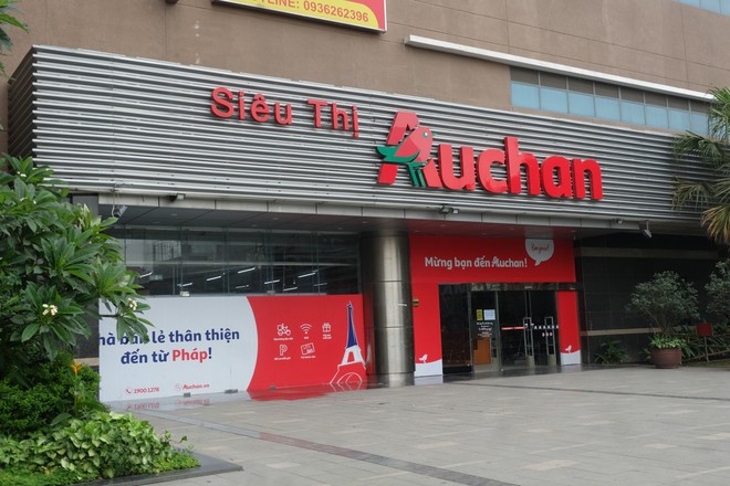 Siêu thị Auchan vắng vẻ, lặng lẽ tháo các kệ hàng sau bão giảm giá - Ảnh 1.